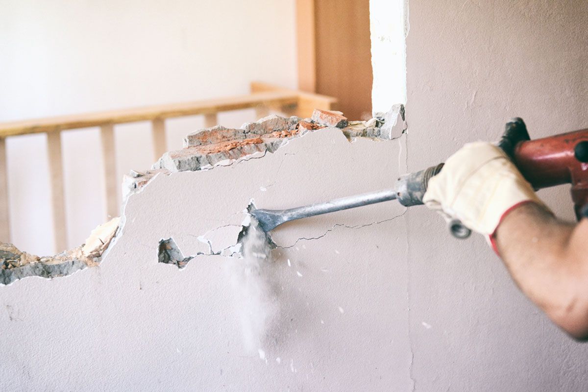 homeguide-demolition-contractor-using-pneumatic-hammer-to-remove-internal-wall